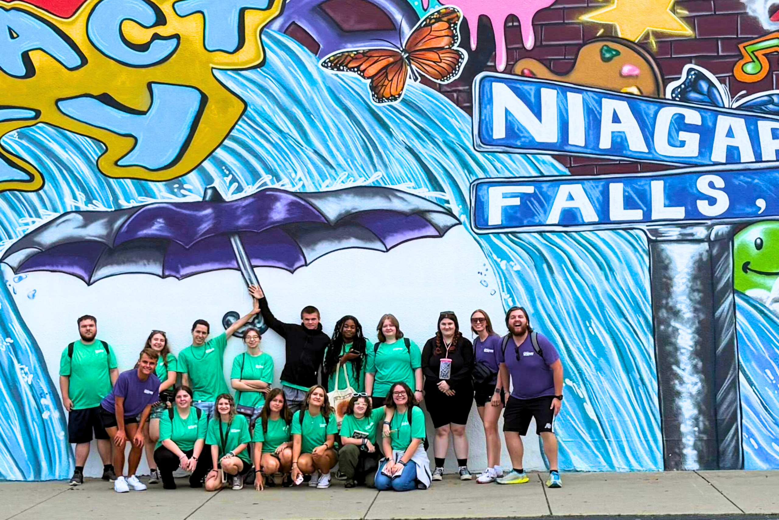 Upward Bound students standing in front of a Niagara Falls mural